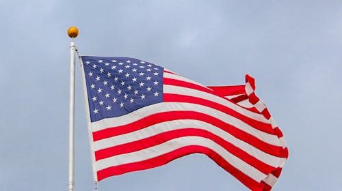 A vibrant image of the American flag waving proudly against a clear blue sky, symbolizing freedom.